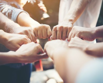 Close up of young people putting their hands together. Team with