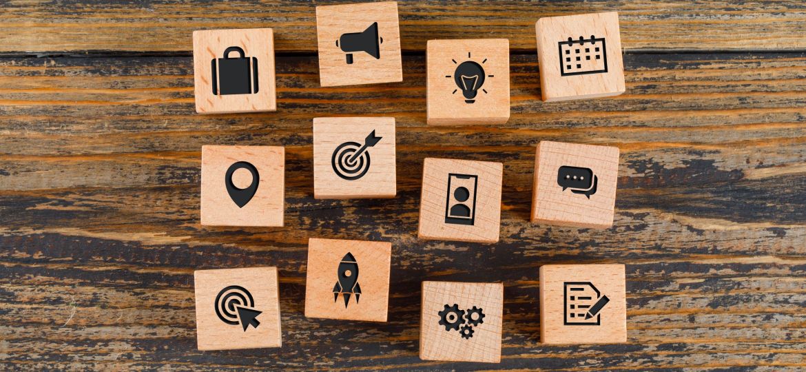 Business concept with icons on wooden cubes on wooden background flat lay.