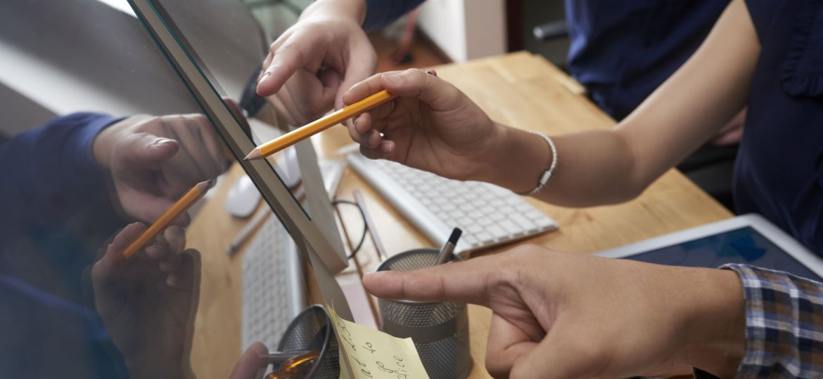 Business people pointing at screen