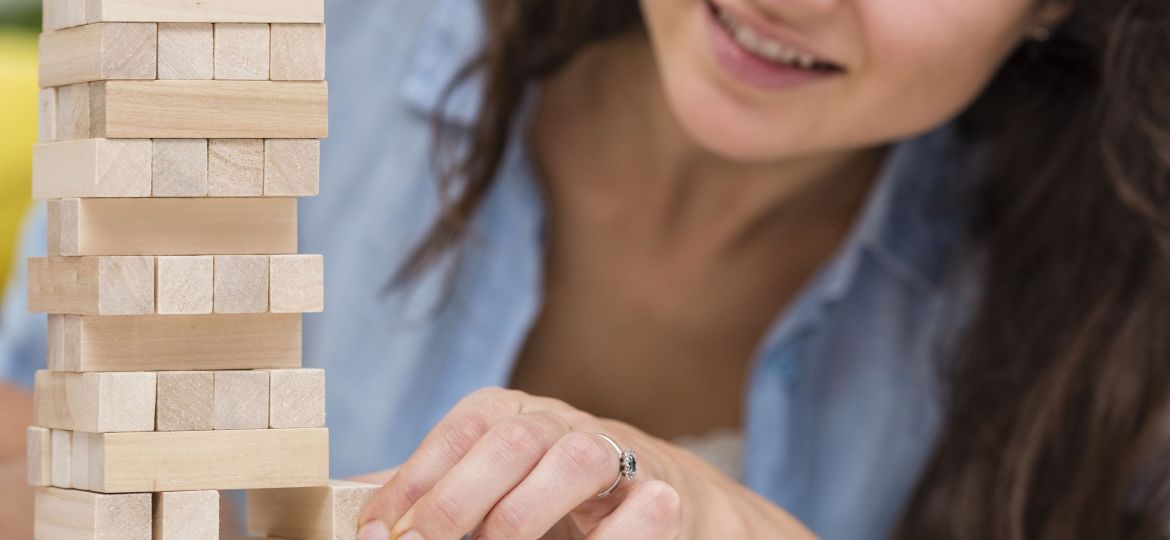 madre-cuidando-mientras-consigue-una-pieza-de-un-juego-de-torre-de-madera