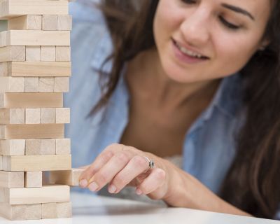 madre-cuidando-mientras-consigue-una-pieza-de-un-juego-de-torre-de-madera
