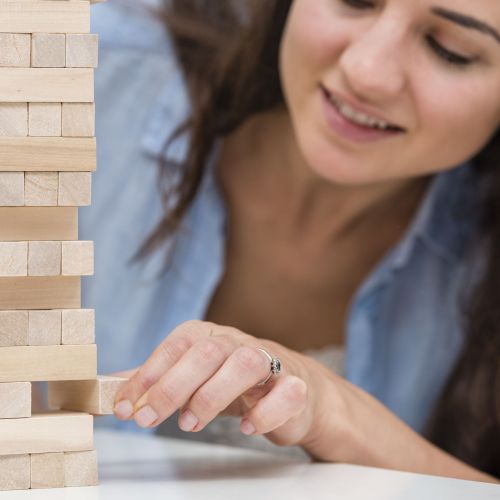madre-cuidando-mientras-consigue-una-pieza-de-un-juego-de-torre-de-madera