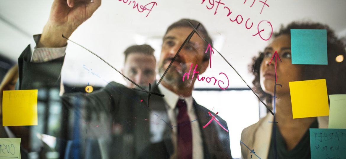 Businesspeople planning on a glass wall