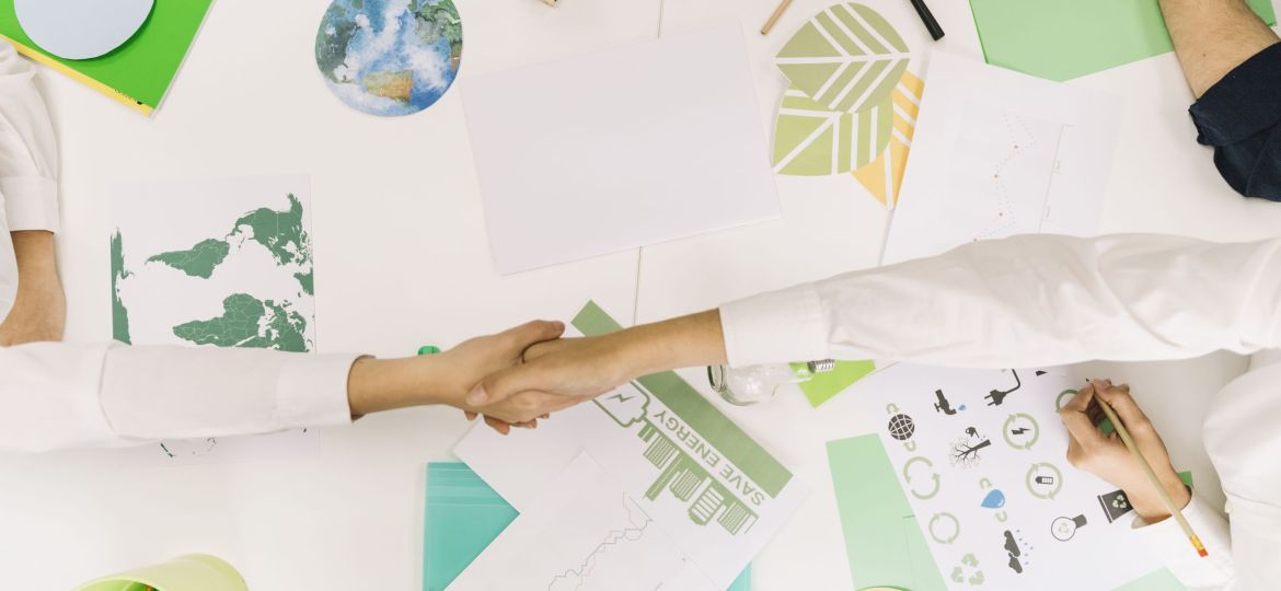 high-angle-view-two-businesspeople-shaking-hands-desk