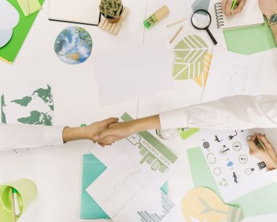high-angle-view-two-businesspeople-shaking-hands-desk