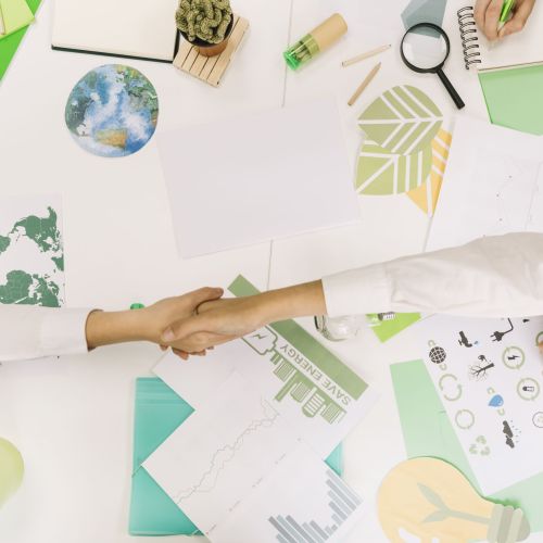 high-angle-view-two-businesspeople-shaking-hands-desk