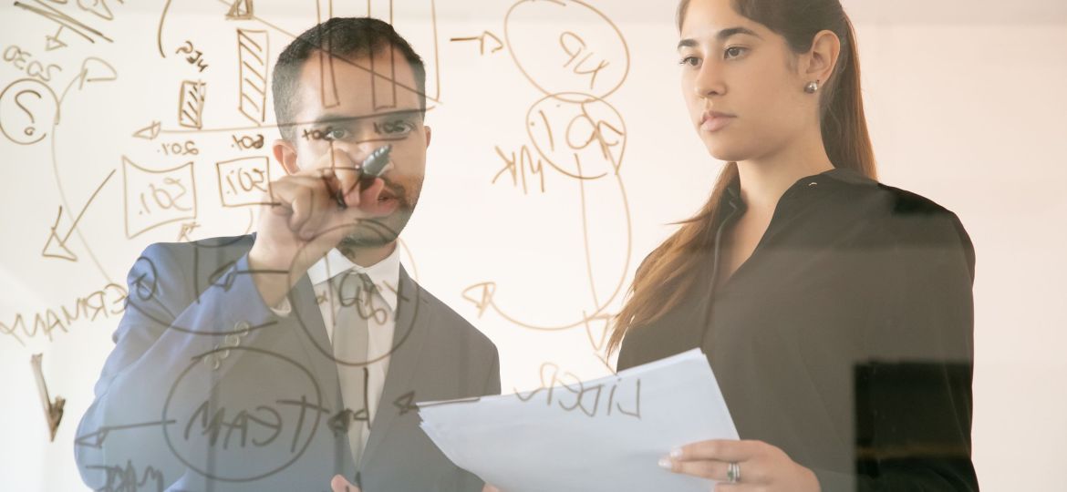 Content African American manager writing chart on glass board