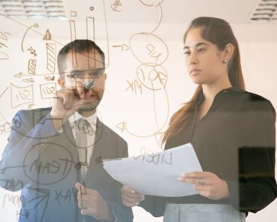 Content African American manager writing chart on glass board