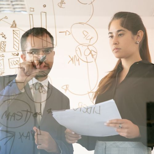 Content African American manager writing chart on glass board